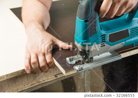 Close-up carpenter working with an electric jigsaw Close-up carpenter working with an electric jigsaw 32166555
