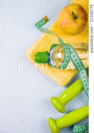 Dumbbells, an apple, a towel and a bottle of water 32168776