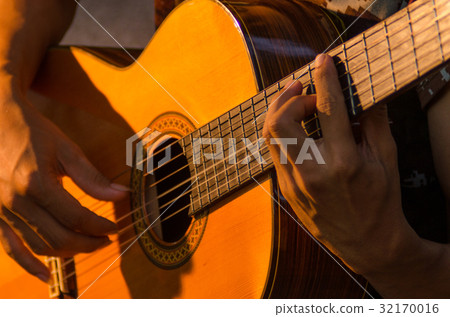 The guitar is placed in the garden next to the hou 32170016