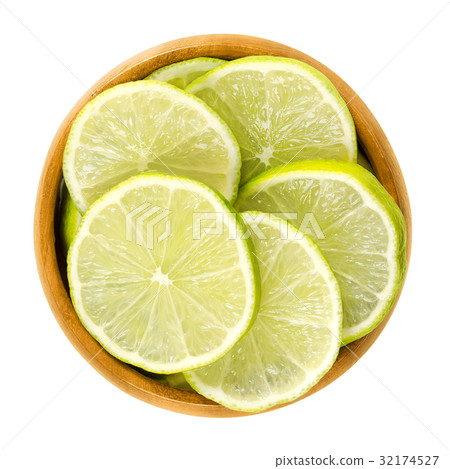 Lime slices in wooden bowl over white 32174527