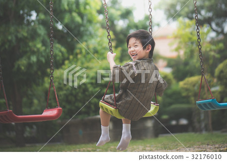 Asian child in kimono playing on swing i Asian child in kimono playing on swing i 32176010
