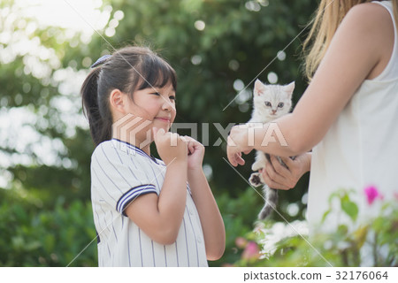 mother giving a kitten to her daughter 32176064