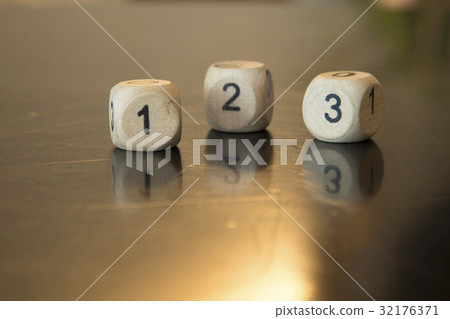Rolling three dice on a wooden desk. Rolling three dice on a wooden desk. 32176371