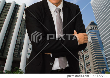 businessman standing on the back of a building businessman standing on the back of a building 32177709