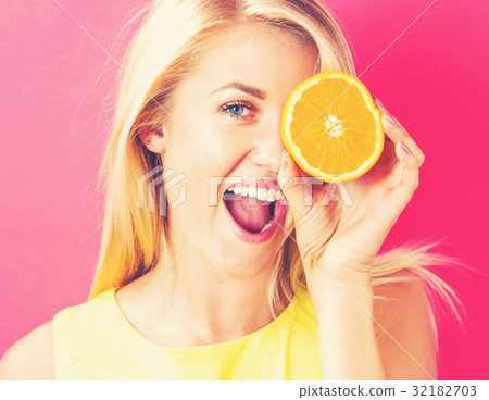 Happy young woman holding oranges halves Happy young woman holding oranges halves 32182703