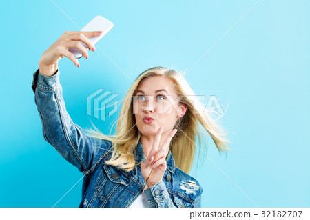 Young woman taking a selfie Young woman taking a selfie 32182707
