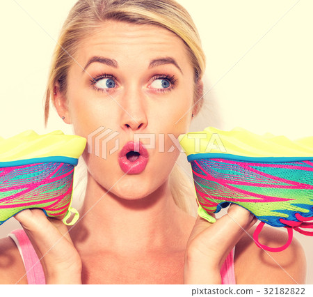 Happy young woman holding shoes 32182822