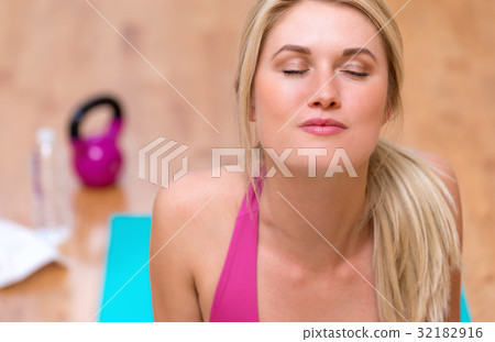 Fit healthy young woman doing stretches Fit healthy young woman doing stretches 32182916