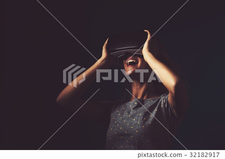 Young woman using virtual reality headset 32182917
