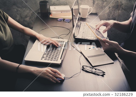 Coworkers working on the same desk Coworkers working on the same desk 32186229