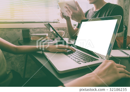 Coworkers working on the same desk Coworkers working on the same desk 32186235
