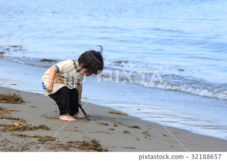 Two-year-old child playing on the beach 32188657