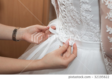 Mom helps daughter to wear wedding dress Mom helps daughter to wear wedding dress 32195622