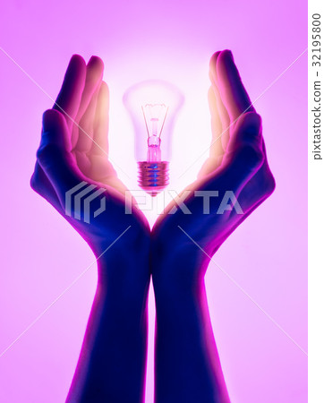 Female hands and holding luminous light bulb. Female hands and holding luminous light bulb. 32195800
