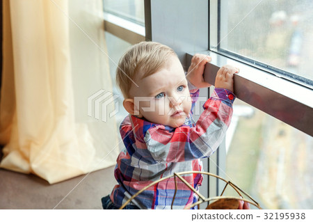 Baby smiles in a room near the window 32195938