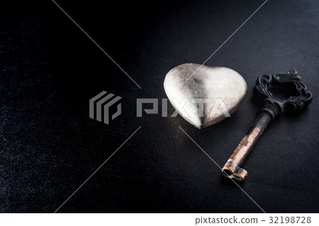Metal heart with key on dark background Metal heart with key on dark background 32198728
