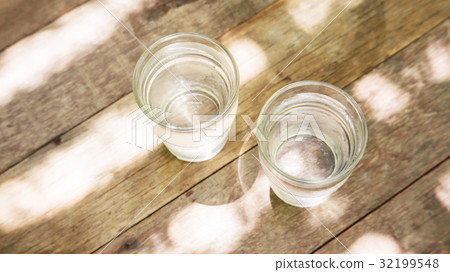 Two glass of water on a wooden table. 32199548