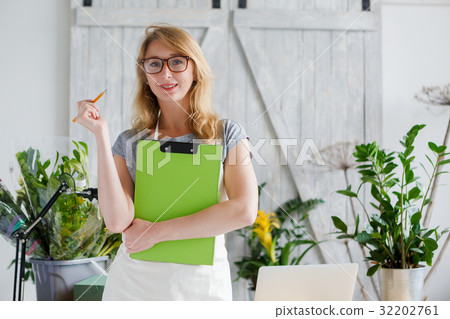 Smiling blond florist with glasses 32202761