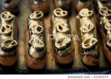 Eclairs, filled with Golden glaze.a work of Eclairs, filled with Golden glaze.a work of 32204255