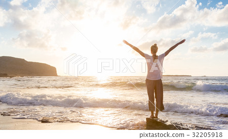 Free Happy Woman Enjoying Sunset on Sandy Beach 32205918