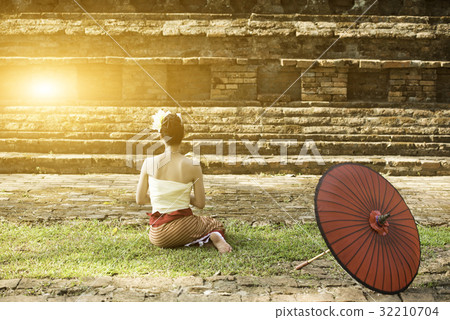 Asian lady in custom sit in front of old stupa Asian lady in custom sit in front of old stupa 32210704