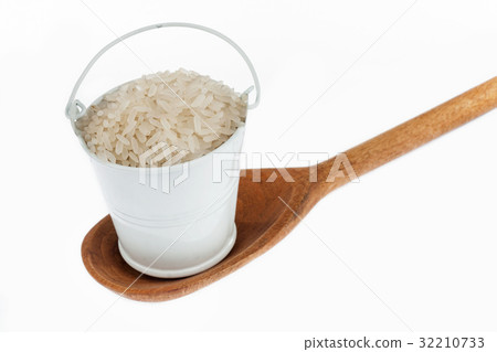 Full bucket of rice grains stands in wooden spoon. Full bucket of rice grains stands in wooden spoon. 32210733