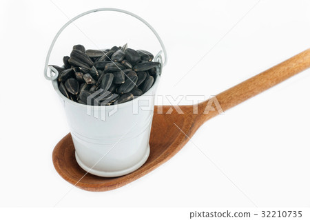 Full bucket of sunflower seeds stands in spoon. Full bucket of sunflower seeds stands in spoon. 32210735