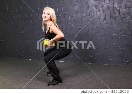 Attractive young fitness woman holding dumbell. 32212033