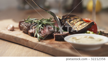 cutting piece from rib eye steak and dip sauce cutting piece from rib eye steak and dip sauce 32212356