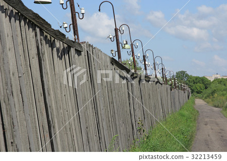 Metal fence wire, grass and sky in the background 32213459