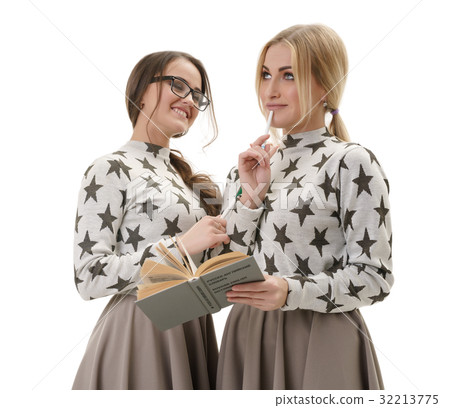 Smart young girls posing in studio with a book 32213775