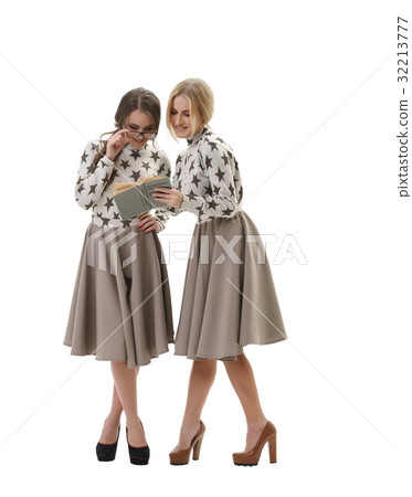 Smart young girls posing in studio with a book 32213777