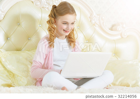 Girl sitting on couch and using modern laptop 32214056