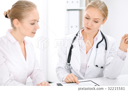 Doctor and  patient  sitting at the desk  32215581
