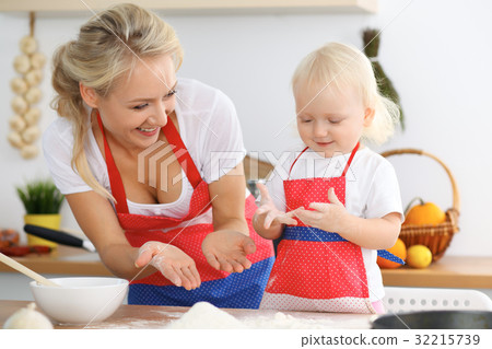 Mother and her little daughter cooking holiday pie Mother and her little daughter cooking holiday pie 32215739