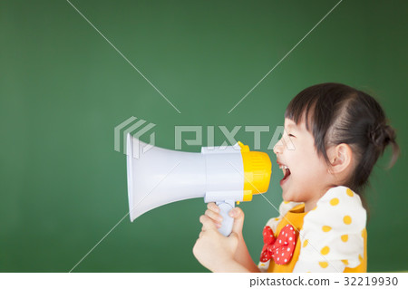 happy kid shouts something into the megaphone 32219930