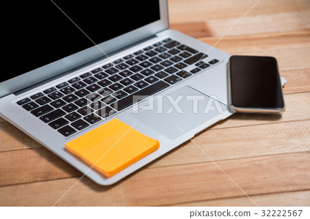 Mobile phone and sticky note on laptop 32222567