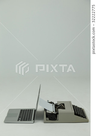 Laptop and typewriter on white background 32222775