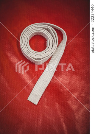 Karate white belt on red background Karate white belt on red background 32224440
