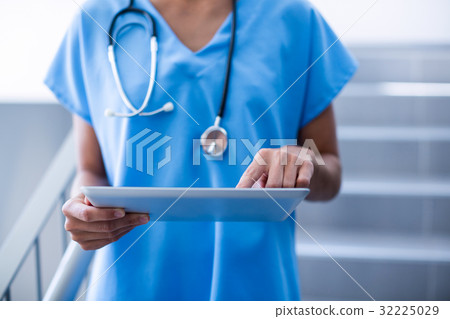 Female surgeon using digital tablet 32225029