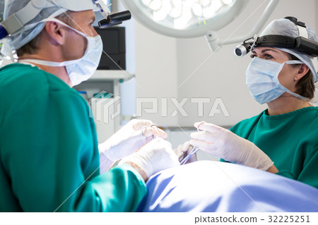 Surgeons interacting while operating patient 32225251