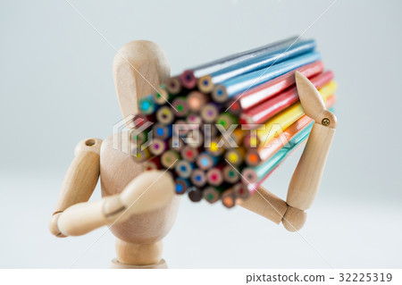 Wooden figurine carrying bunch of pencils 32225319