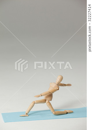 Wooden figurine exercising on exercise mat Wooden figurine exercising on exercise mat 32227414