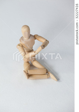 Wooden figurine performing yoga on floor Wooden figurine performing yoga on floor 32227416