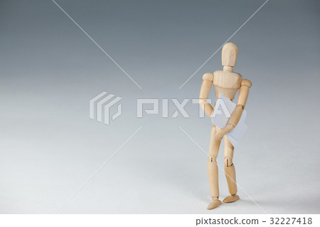 Wooden figurine standing and holding documents 32227418