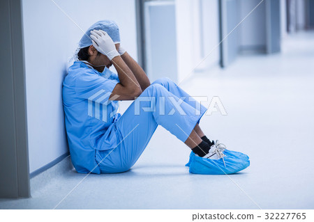 Sad surgeon sitting on a floor 32227765