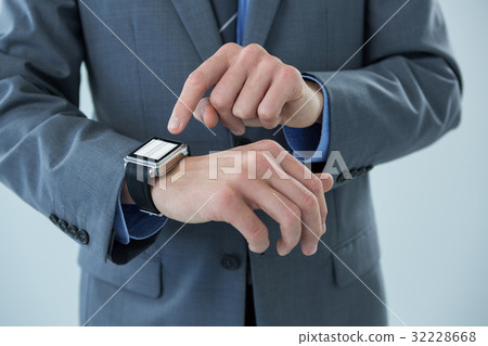 Businessman using his smart watch Businessman using his smart watch 32228668