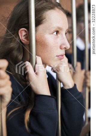 Young sad and boredom schoolgirl holding at the gate Young sad and boredom schoolgirl holding at the gate 32228873