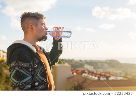 Portrait of a man drinking water from a bottle Portrait of a man drinking water from a bottle 32233423