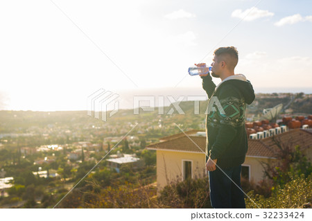 Portrait of a man drinking water from a bottle Portrait of a man drinking water from a bottle 32233424